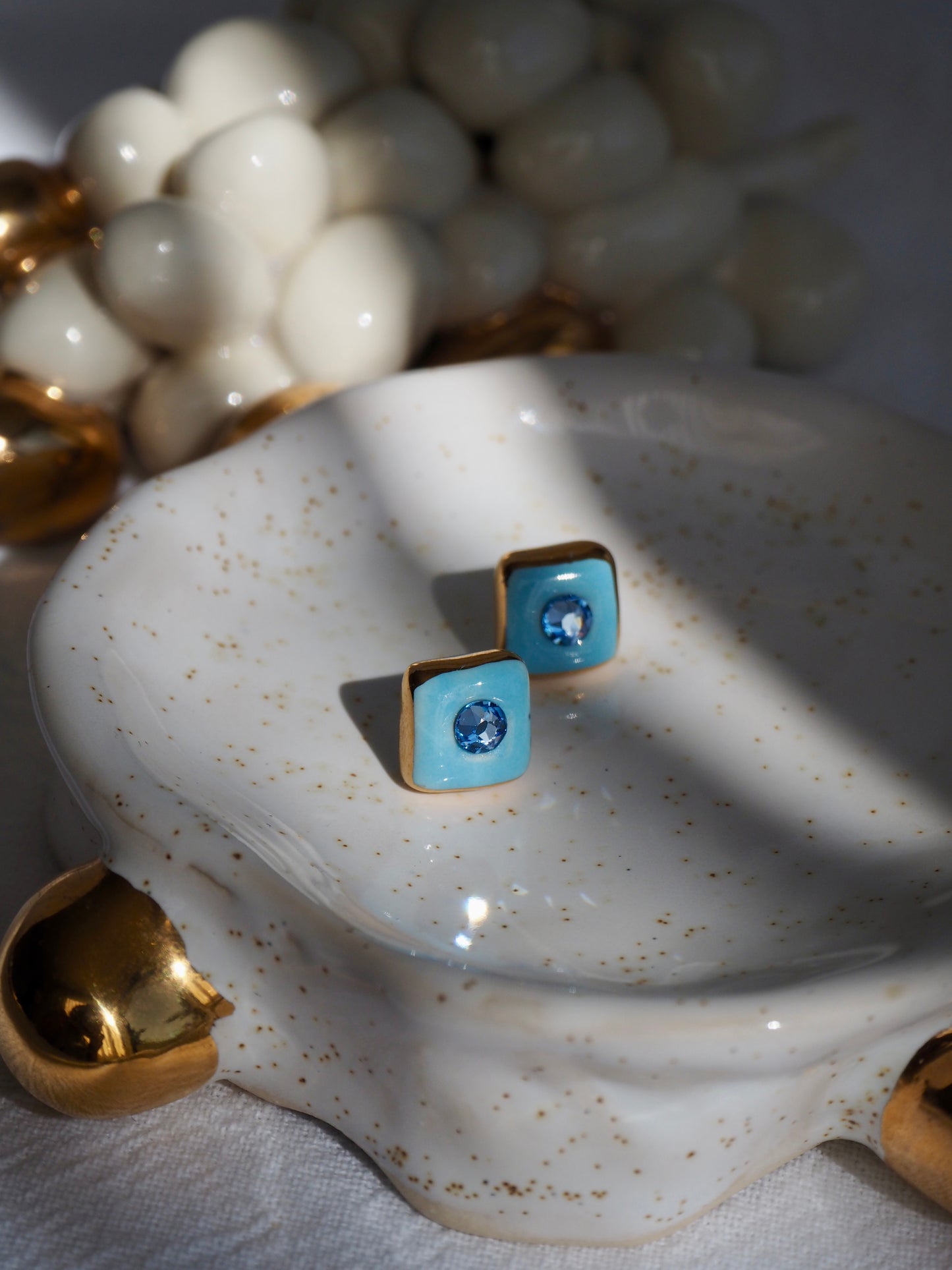 “Supernova” Light Blue Small Square Handmade Porcelain Studs with 24k Gold lustre rims and Swarovskis Crystal.