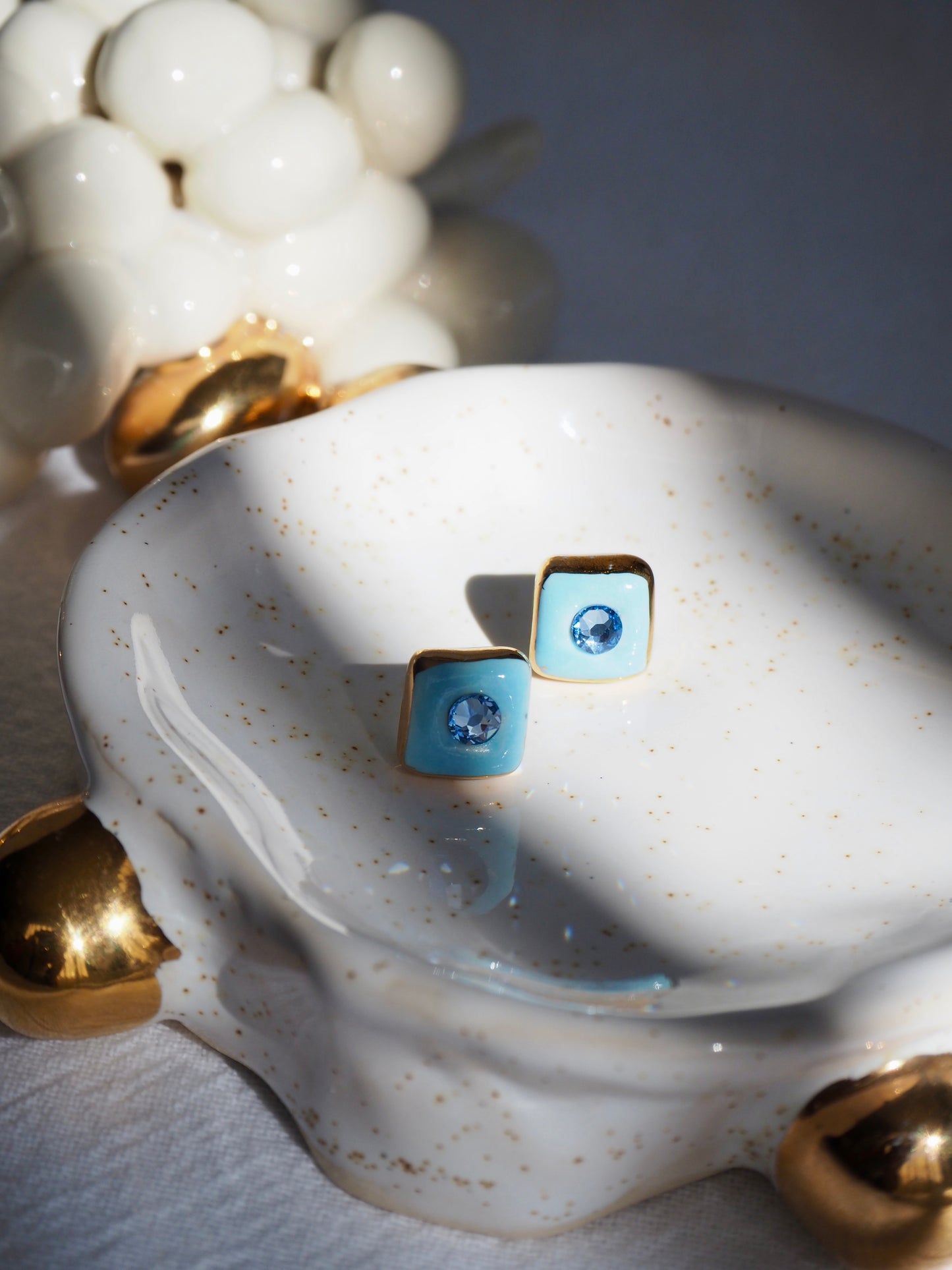 “Supernova” Light Blue Small Square Handmade Porcelain Studs with 24k Gold lustre rims and Swarovskis Crystal.