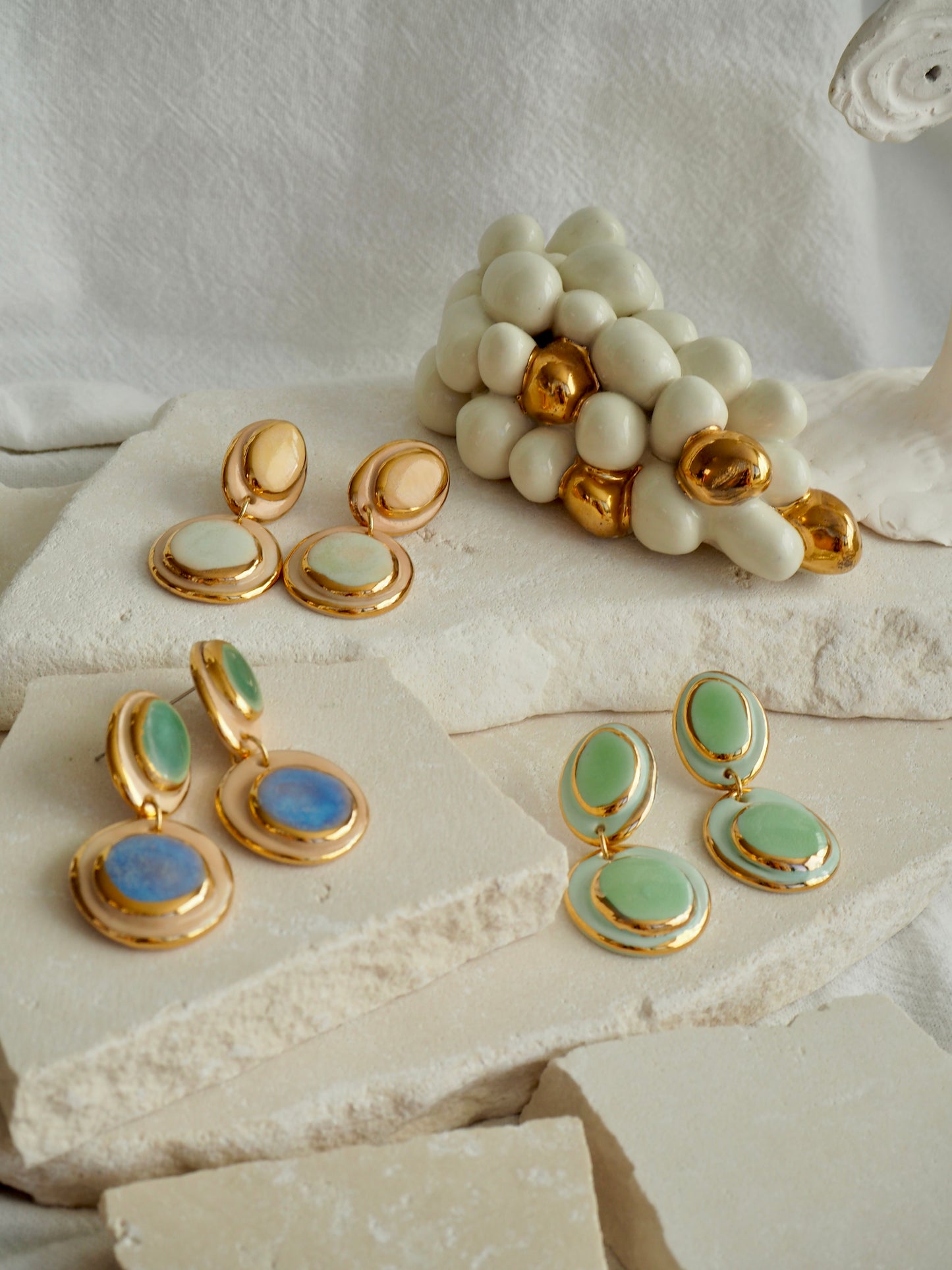 Femminilità Porcelain Earrings in Mint Green coloured glossy glaze on Parchment underglaze with 24k Gold lustre textured rims