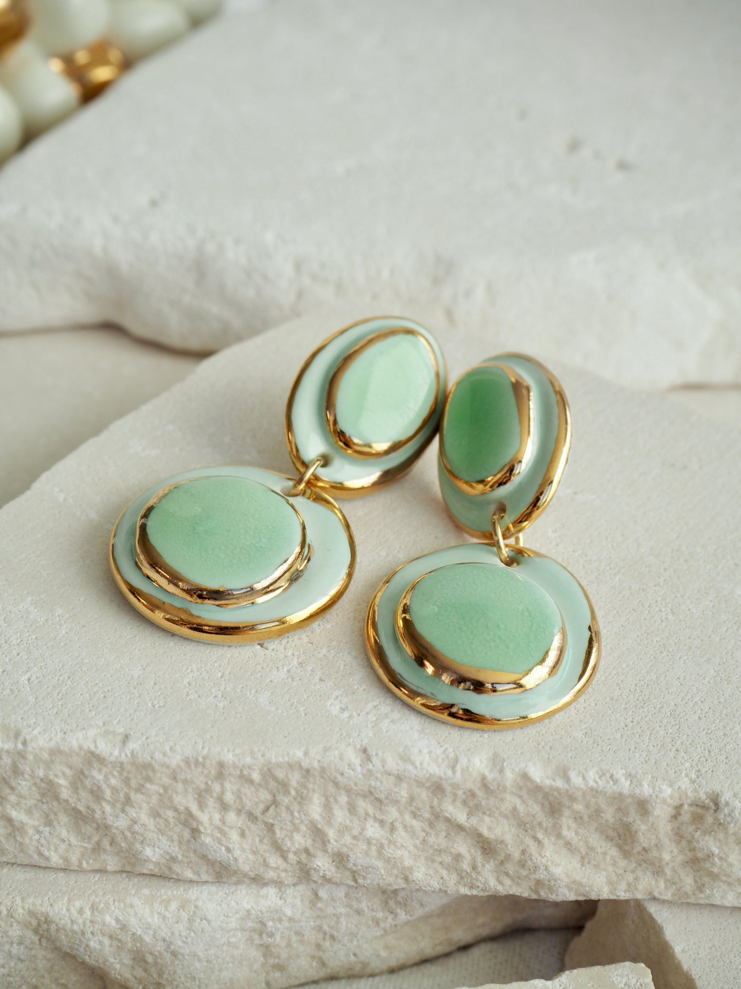 Femminilità Porcelain Earrings in Mint Green coloured glossy glaze on Parchment underglaze with 24k Gold lustre textured rims